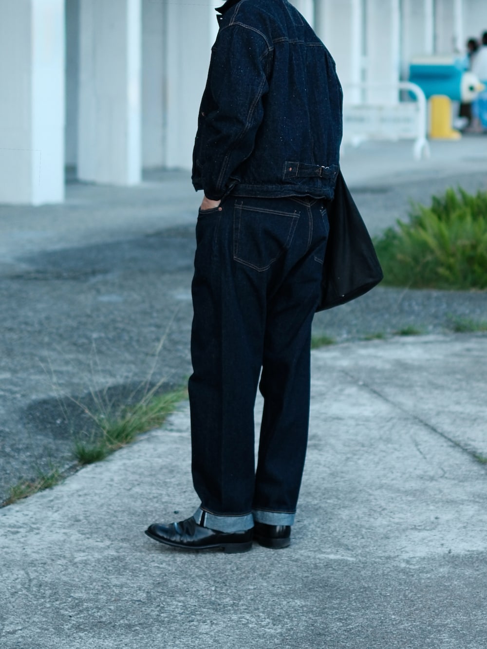 ブルー系のデニムパンツ、ブラック系のブーツ、ブラック系のトートバッグを着用したメンズの冬コーディネートの5枚目の写真