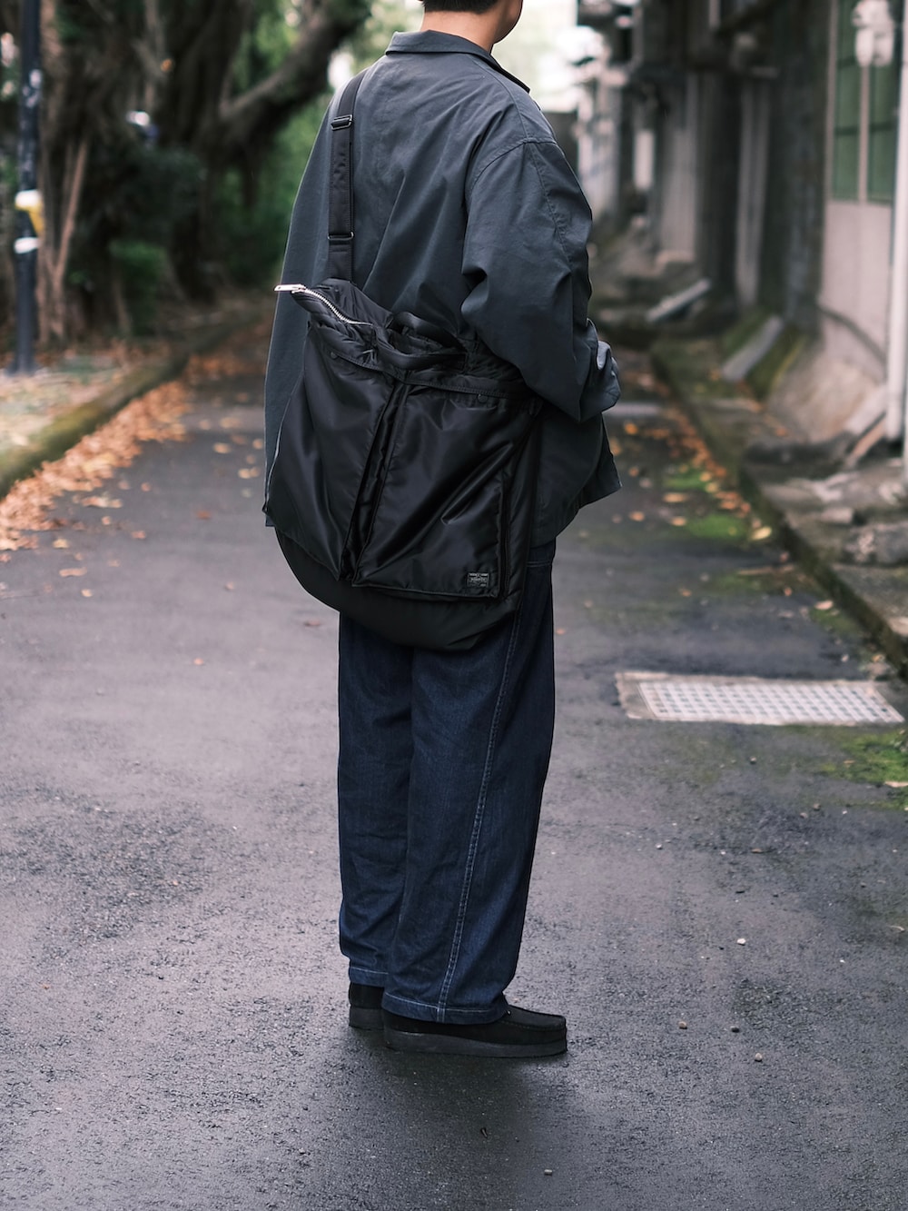 ブラック系のその他アウター、グレー系のTシャツ/カットソー、ブラック系のトートバッグを着用したメンズの秋コーディネートの4枚目の写真