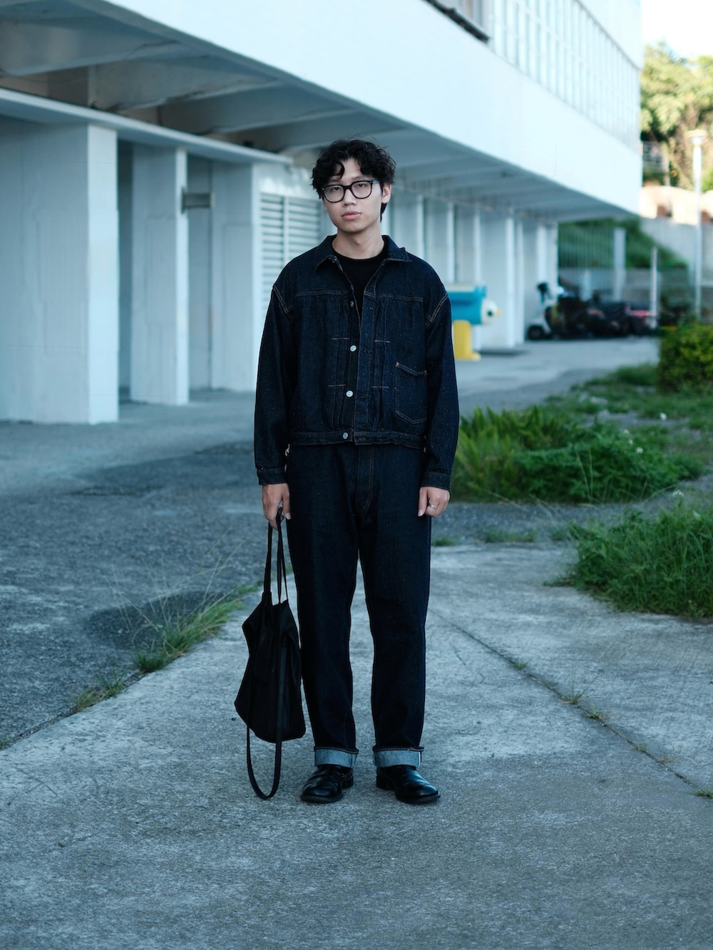 ブルー系のデニムパンツ、ブラック系のブーツ、ブラック系のトートバッグを着用したメンズの冬コーディネートの4枚目の写真