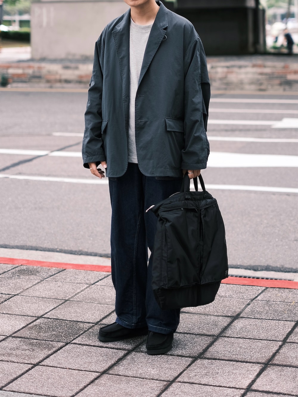 ブラック系のその他アウター、グレー系のTシャツ/カットソー、ブラック系のトートバッグを着用したメンズの秋コーディネートの3枚目の写真