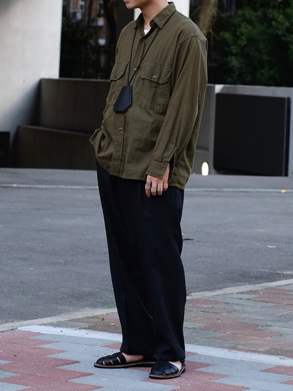 グリーン系のシャツ/ブラウス、ホワイト系のTシャツ/カットソー、ブラック系のスラックスを着用したメンズの冬コーディネートの5枚目の写真