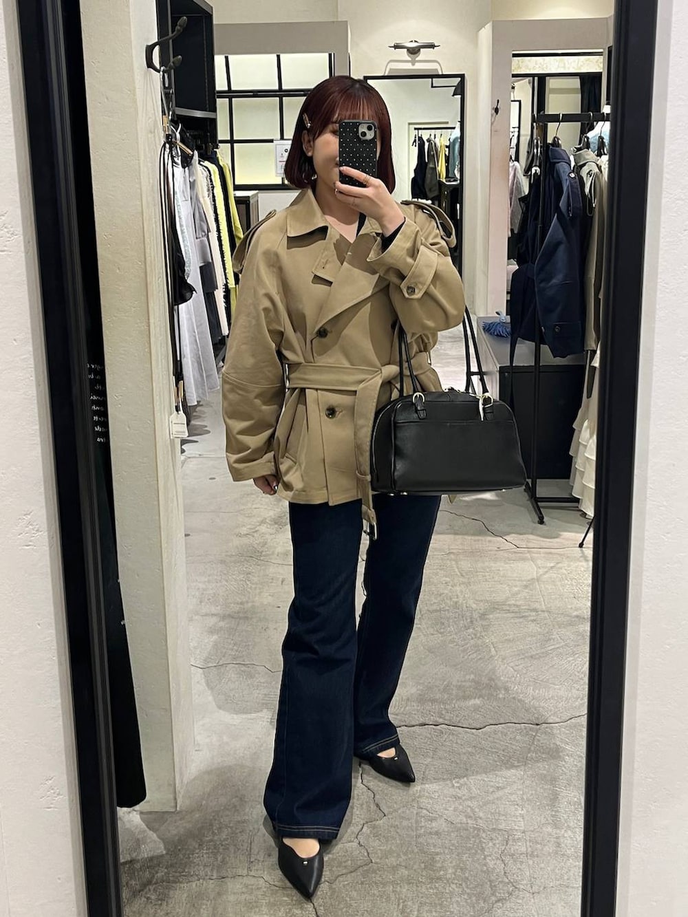 ブラック系のハンドバッグ、ブルー系のデニムパンツ、ブラック系のパンプスを着用したレディースの冬コーディネートの9枚目の写真