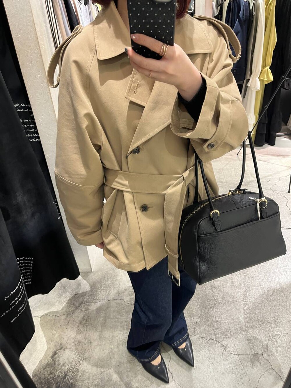 ブラック系のハンドバッグ、ブルー系のデニムパンツ、ブラック系のパンプスを着用したレディースの冬コーディネートの8枚目の写真