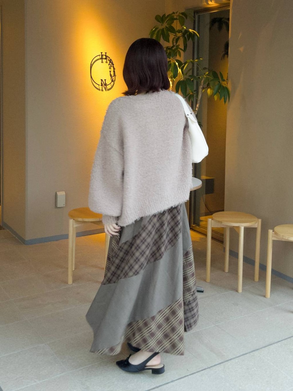 ホワイト系のショルダーバッグ、ベージュ系のカーディガン/ボレロ、ブラウン系のワンピースを着用したレディースの秋コーディネートの6枚目の写真