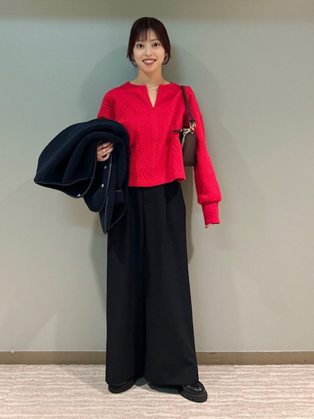 ブラック系のローファー、レッド系のショルダーバッグ、レッド系のスウェットを着用したレディースの秋コーディネートの2枚目の写真