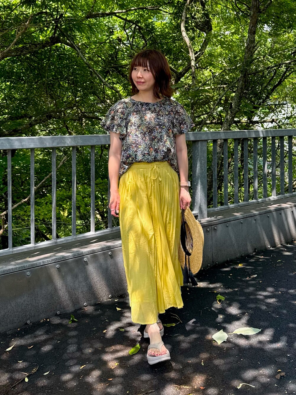 イエロー系のスカート、ブルー系のシャツ/ブラウスを着用したレディースの夏コーディネートの3枚目の写真