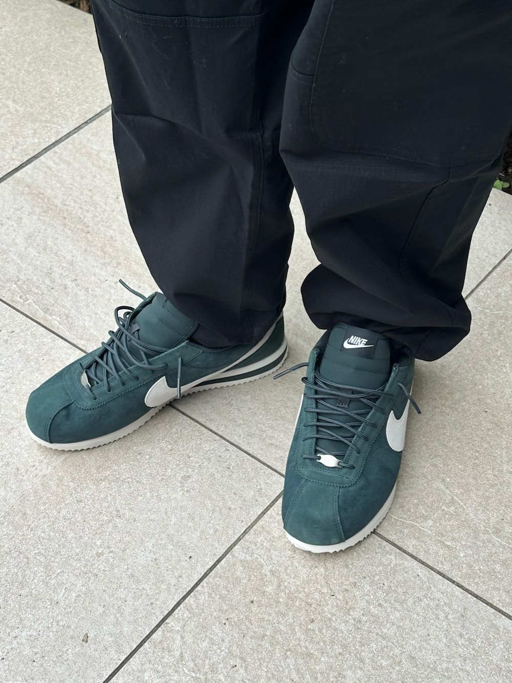 ブラック系のカーゴパンツ、ブラック系のその他トップス、グリーン系のスニーカーを着用したレディースの秋コーディネートの4枚目の写真