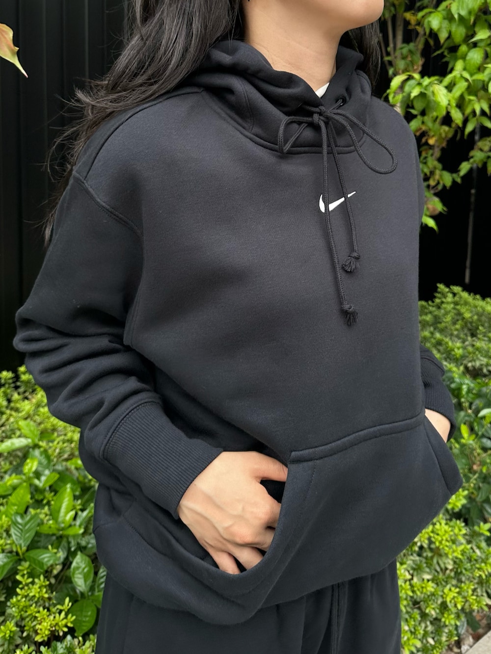 ブラック系のスニーカー、ブラック系のパーカー、ブラック系のスウェットパンツを着用したレディースの秋コーディネートの2枚目の写真