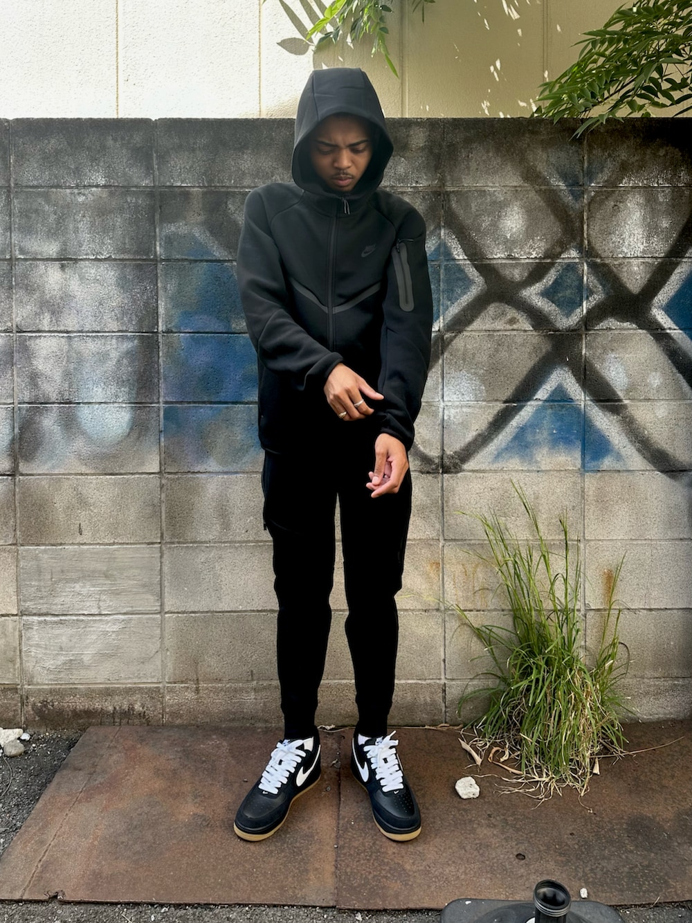 ブラック系のパーカー、ブラック系のその他パンツ、ブラック系のスニーカーを着用したメンズの秋コーディネートの2枚目の写真