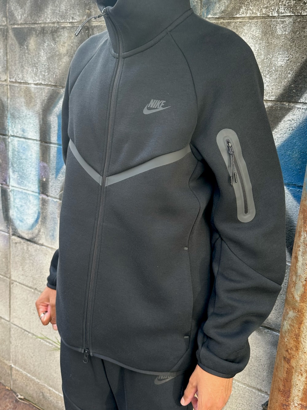 ブラック系のパーカー、ブラック系のその他パンツ、ブラック系のスニーカーを着用したメンズの秋コーディネートの3枚目の写真