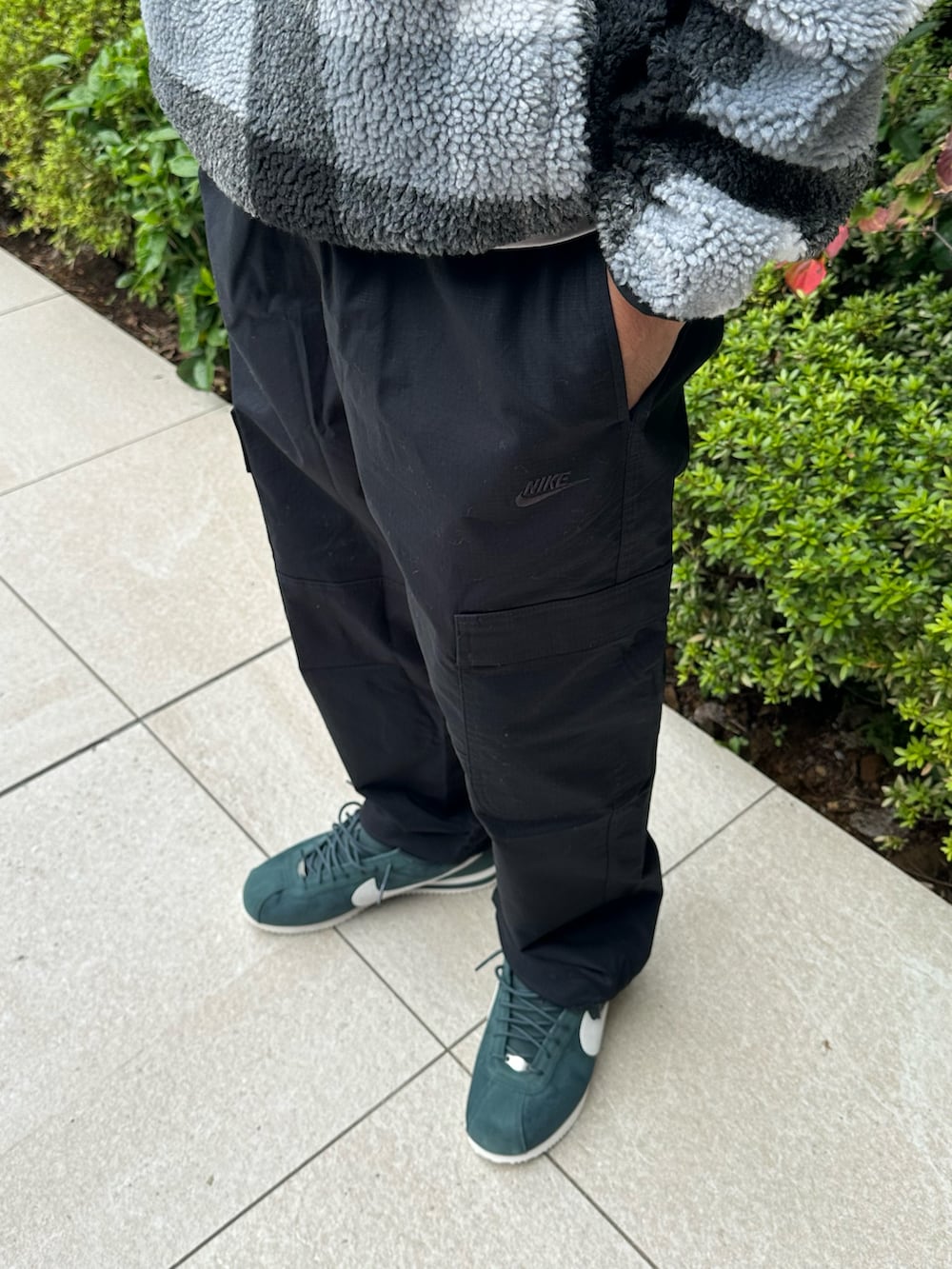 ブラック系のカーゴパンツ、ブラック系のその他トップス、グリーン系のスニーカーを着用したレディースの秋コーディネートの3枚目の写真