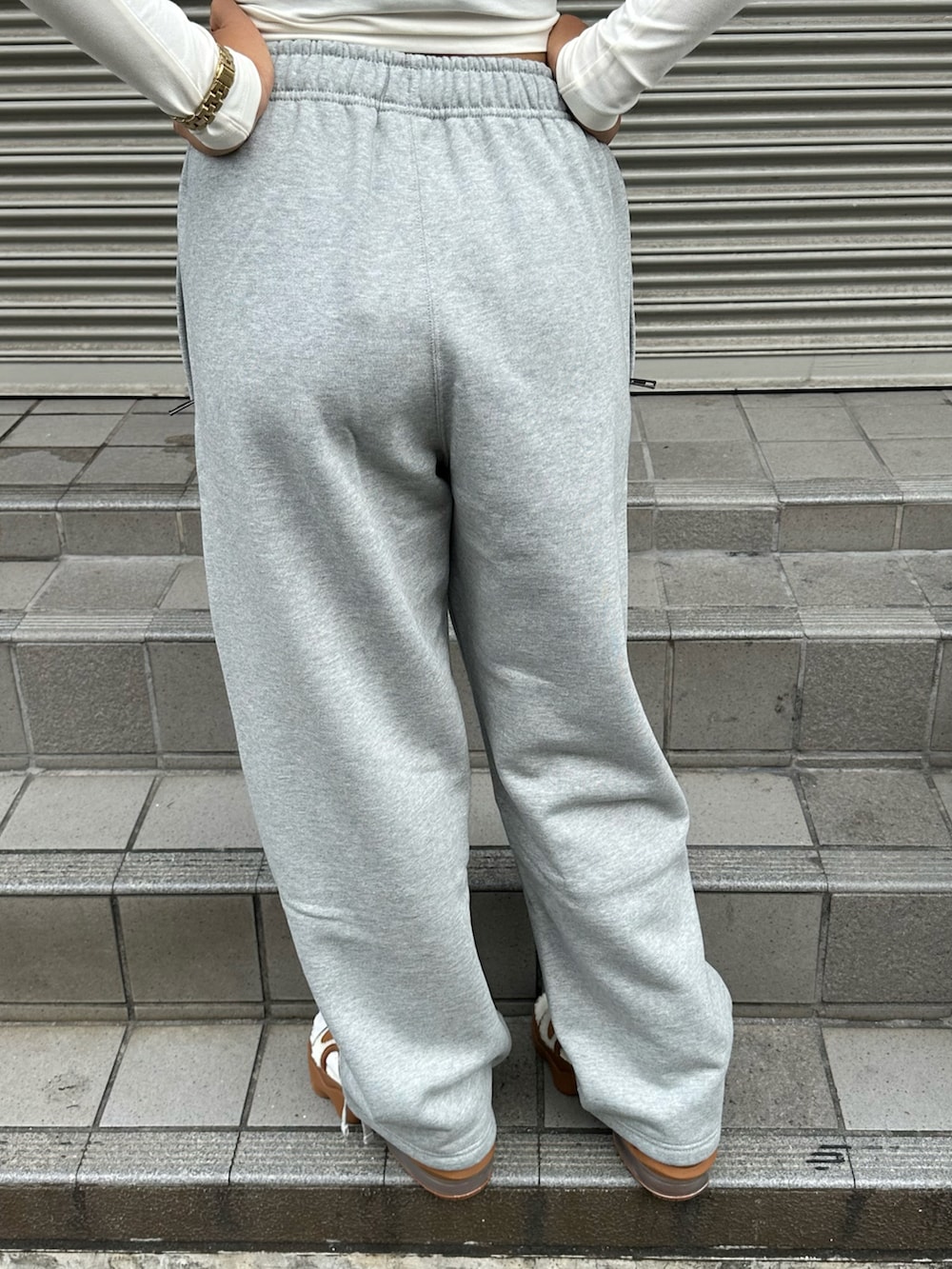 ホワイト系のTシャツ/カットソー、ブラウン系のサンダル、グレー系のスウェットパンツを着用したレディースの秋コーディネートの4枚目の写真