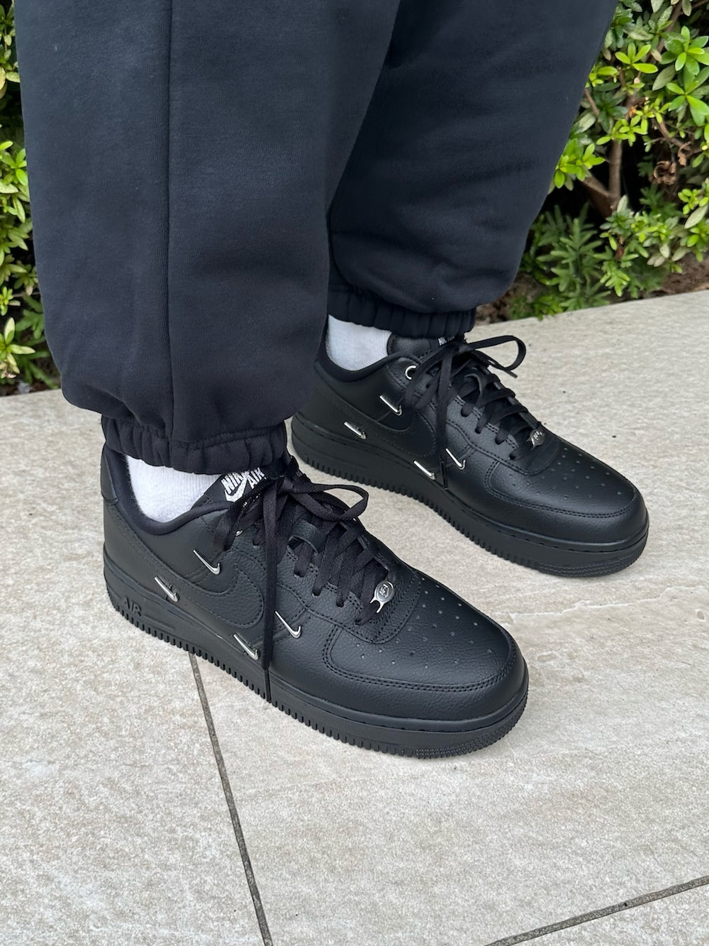 ブラック系のスニーカー、ブラック系のパーカー、ブラック系のスウェットパンツを着用したレディースの秋コーディネートの4枚目の写真