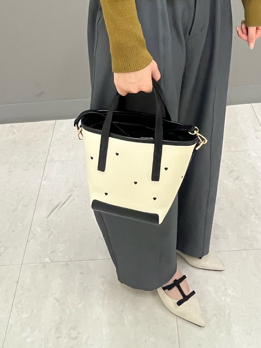 グレー系のその他パンツ、イエロー系のカーディガン/ボレロ、ホワイト系のパンプスを着用したレディースの秋コーディネートの4枚目の写真