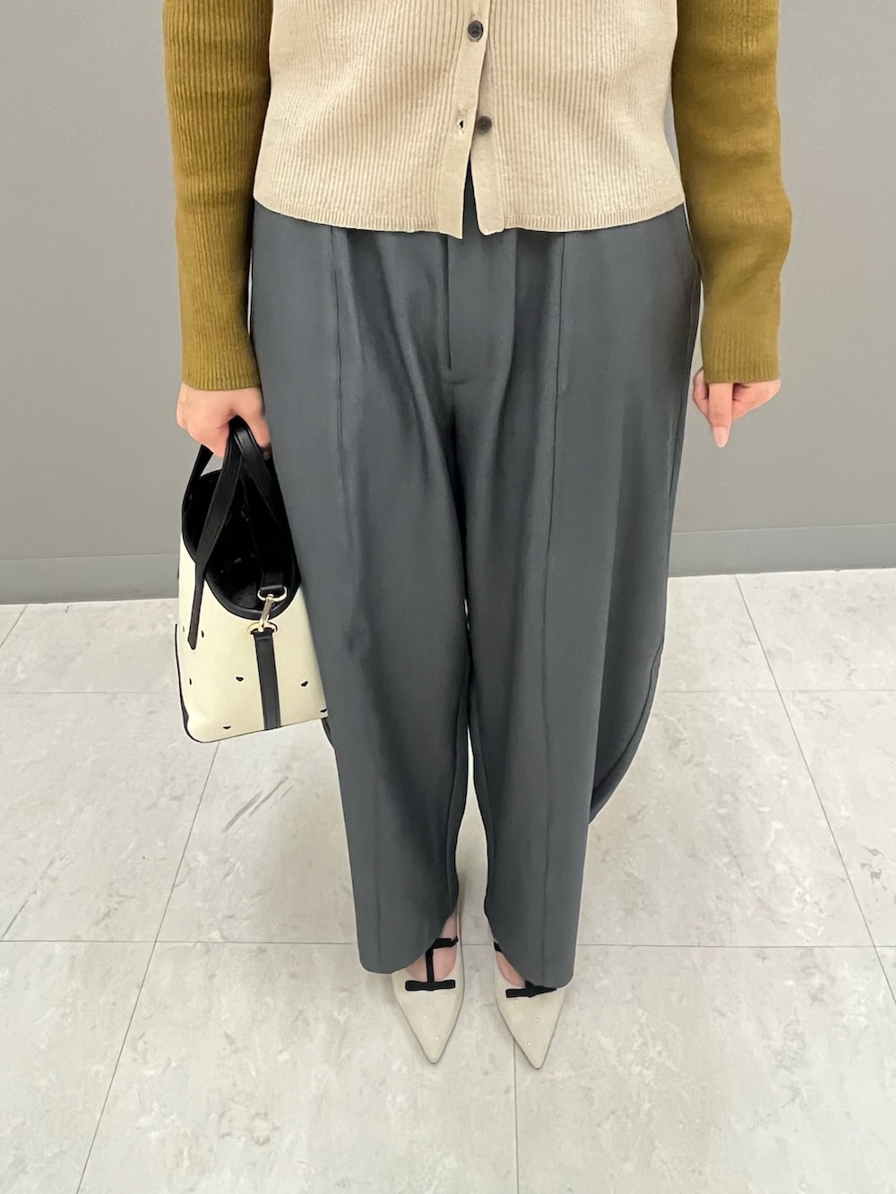 グレー系のその他パンツ、イエロー系のカーディガン/ボレロ、ホワイト系のパンプスを着用したレディースの秋コーディネートの3枚目の写真