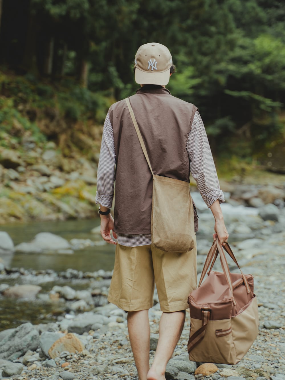 ブラウン系のベスト、ベージュ系のショルダーバッグ、ブラウン系のサンダルを着用したメンズの夏コーディネートの5枚目の写真