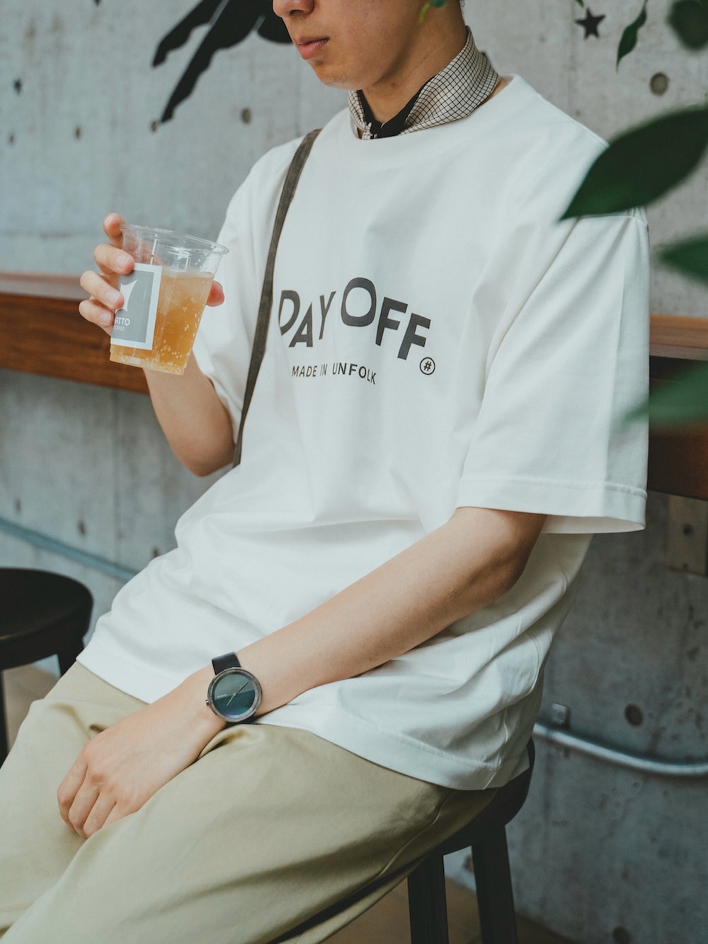 ホワイト系のTシャツ/カットソー、ベージュ系のチノパンツ、ブラック系のブーツを着用したメンズの夏コーディネートの3枚目の写真