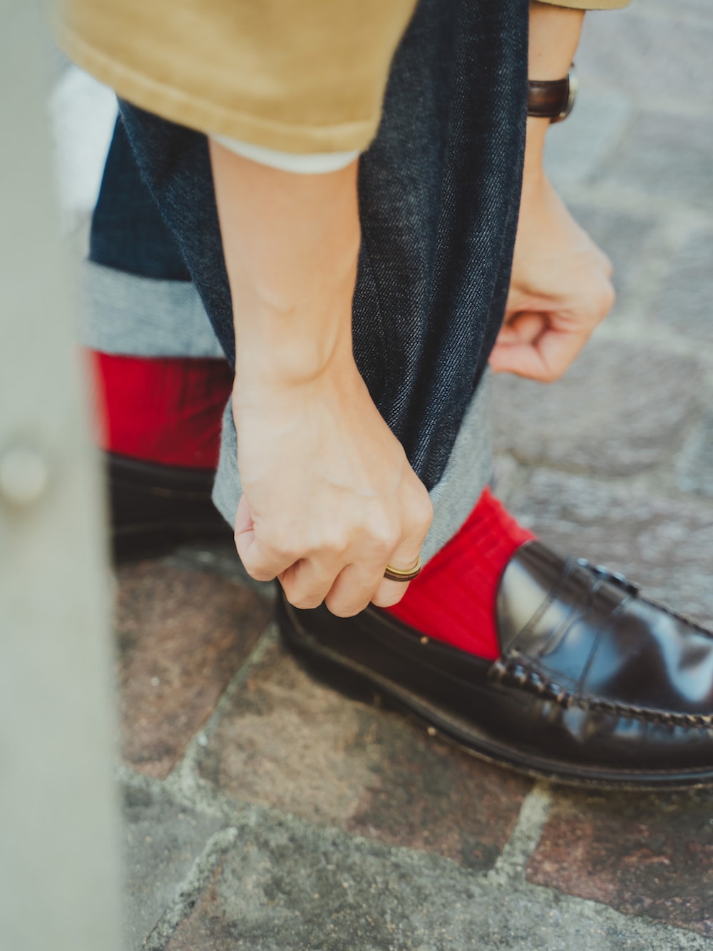 ベージュ系のノーカラーコート、ホワイト系のシャツ/ブラウス、ブルー系のデニムパンツを着用したメンズの秋コーディネートの4枚目の写真