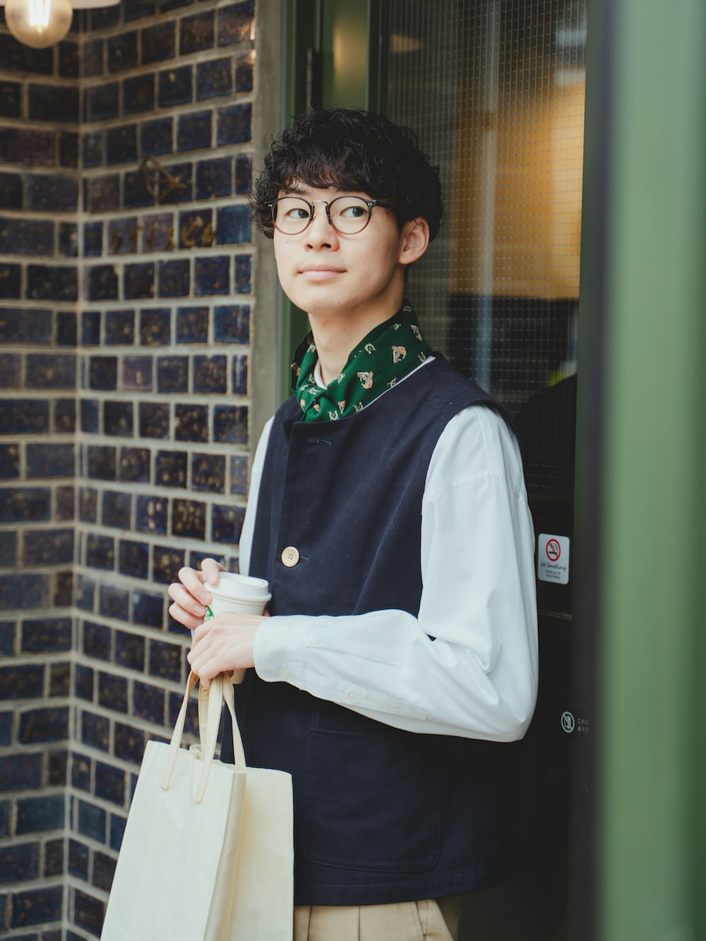 「メガネ男子、ベスト、ジレ、スカーフ、白シャツ、シャツスタイル、レイヤードスタイル、重ね着、チノパン、ワイドパンツ、ローファー、トートバッグ、FUDGE、トラッド、きれいめカジュアル」|「UNFOLKの#-48 Peach brushed classic vest / サイズ2(ベスト、ブルー系)」を使った、三木 克海さん(メンズ・175cm)の春コーディネートの2枚目の写真