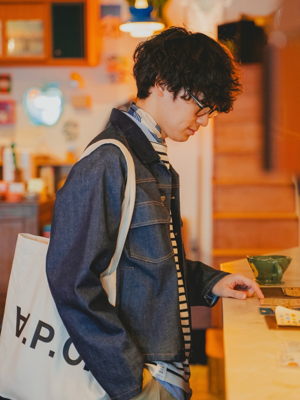 ホワイト系のスニーカー、ホワイト系のトートバッグ、ブルー系のニット/セーターを着用したメンズの冬コーディネートの2枚目の写真