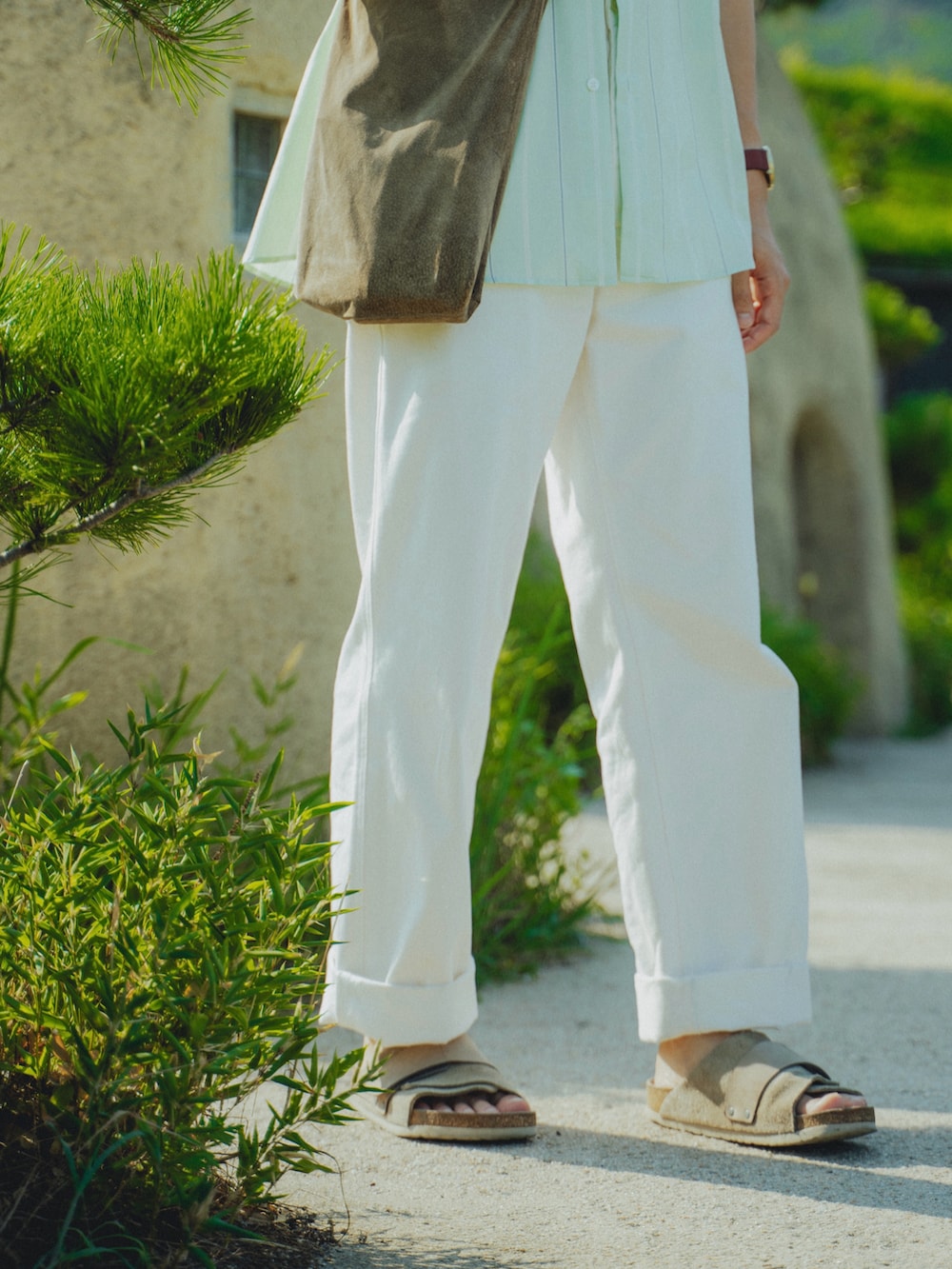 ベージュ系のショルダーバッグ、ホワイト系のその他パンツ、ベージュ系のサンダルを着用したメンズの夏コーディネートの5枚目の写真