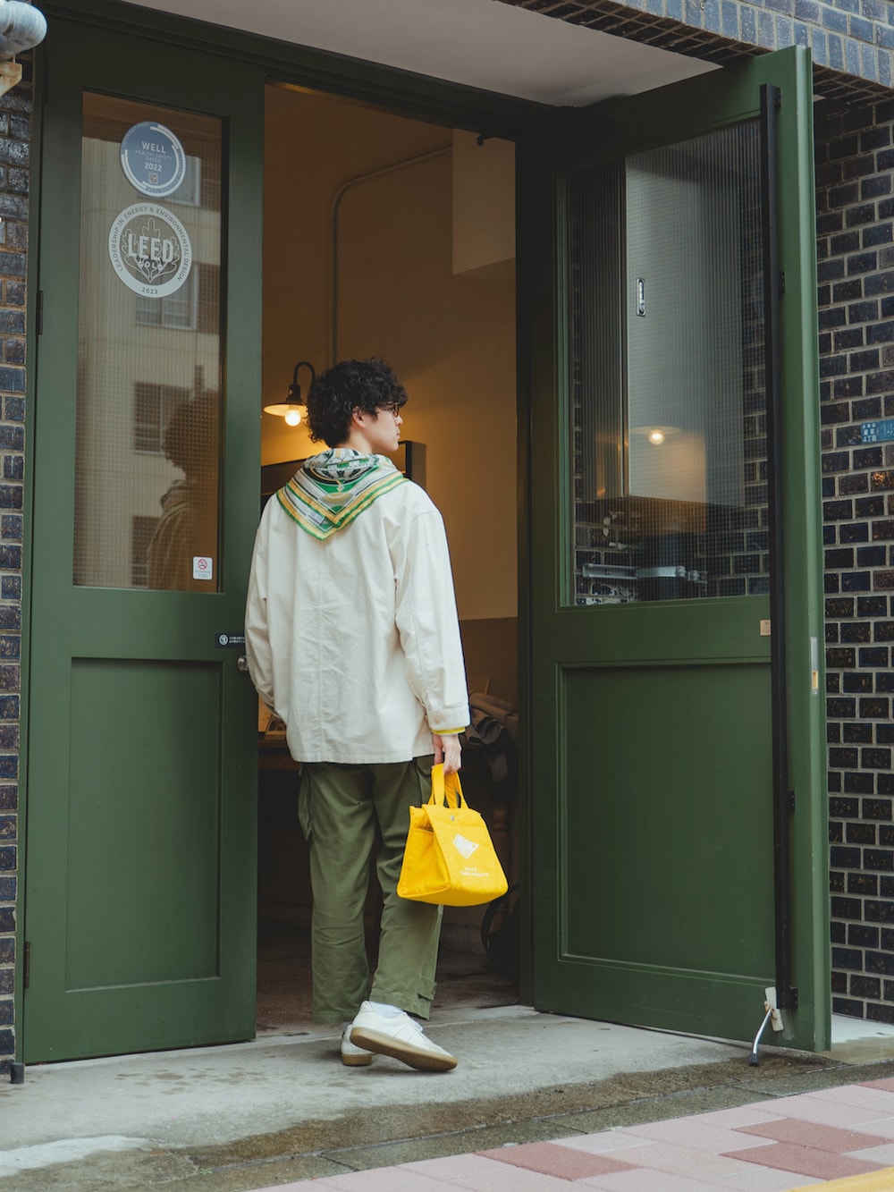 ホワイト系のカバーオール、イエロー系のTシャツ/カットソー、グリーン系のカーゴパンツを着用したメンズの春コーディネートの5枚目の写真