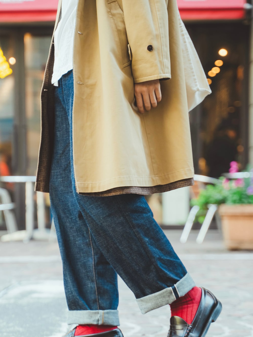 ベージュ系のノーカラーコート、ホワイト系のシャツ/ブラウス、ブルー系のデニムパンツを着用したメンズの秋コーディネートの3枚目の写真