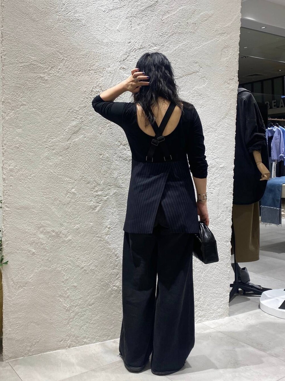 ブラック系のデニムパンツ、ブルー系のベスト、ブラック系のTシャツ/カットソーを着用したレディースの夏コーディネートの3枚目の写真