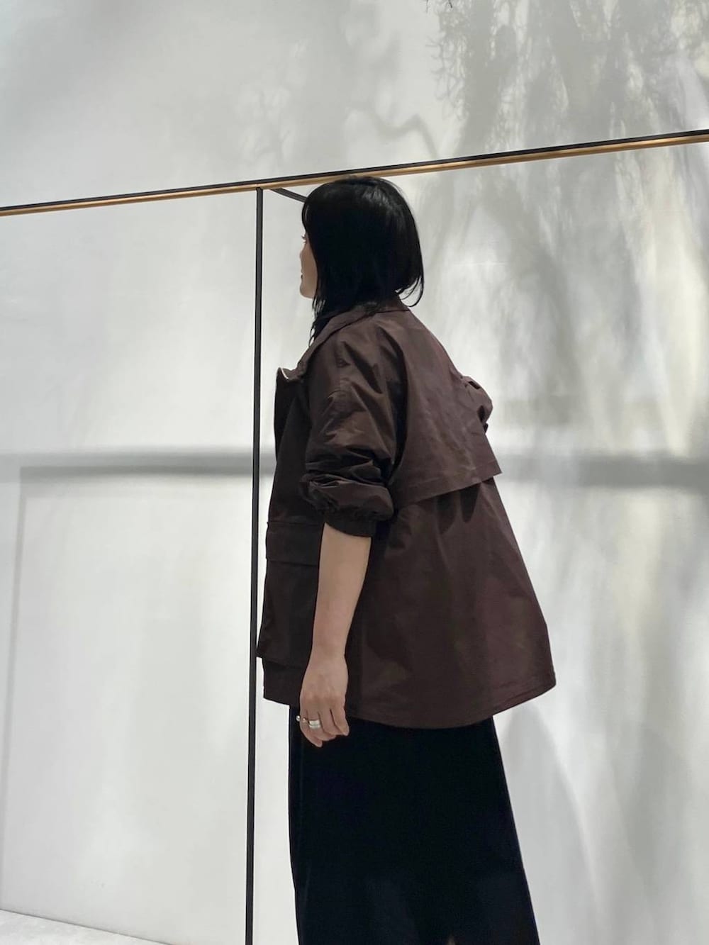 ブラック系のスカート、ブラウン系のTシャツ/カットソー、ブラウン系のブルゾンを着用したレディースの夏コーディネートの4枚目の写真