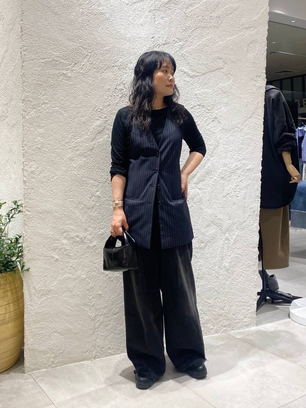 ブラック系のデニムパンツ、ブルー系のベスト、ブラック系のTシャツ/カットソーを着用したレディースの夏コーディネートの4枚目の写真