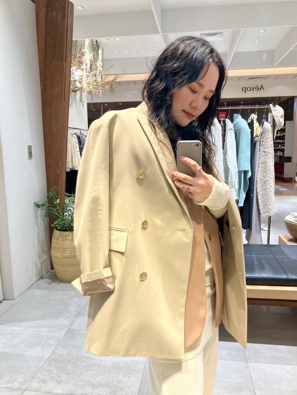 ベージュ系のショルダーバッグ、ベージュ系のテーラードジャケット、ベージュ系のその他アウターを着用したレディースの冬コーディネートの5枚目の写真