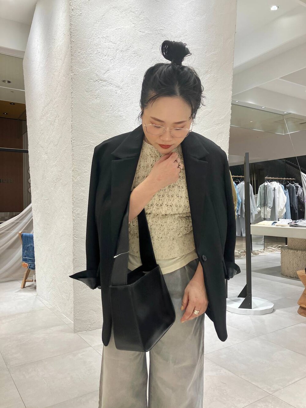 グレー系のデニムパンツ、ホワイト系のベスト、ブラック系のテーラードジャケットを着用したレディースの冬コーディネートの6枚目の写真