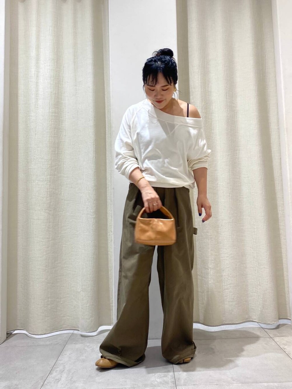 グリーン系のチノパンツ、ホワイト系のTシャツ/カットソーを着用したレディースの夏コーディネートの4枚目の写真