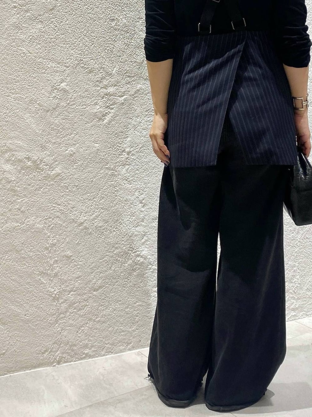 ブラック系のデニムパンツ、ブルー系のベスト、ブラック系のTシャツ/カットソーを着用したレディースの夏コーディネートの6枚目の写真