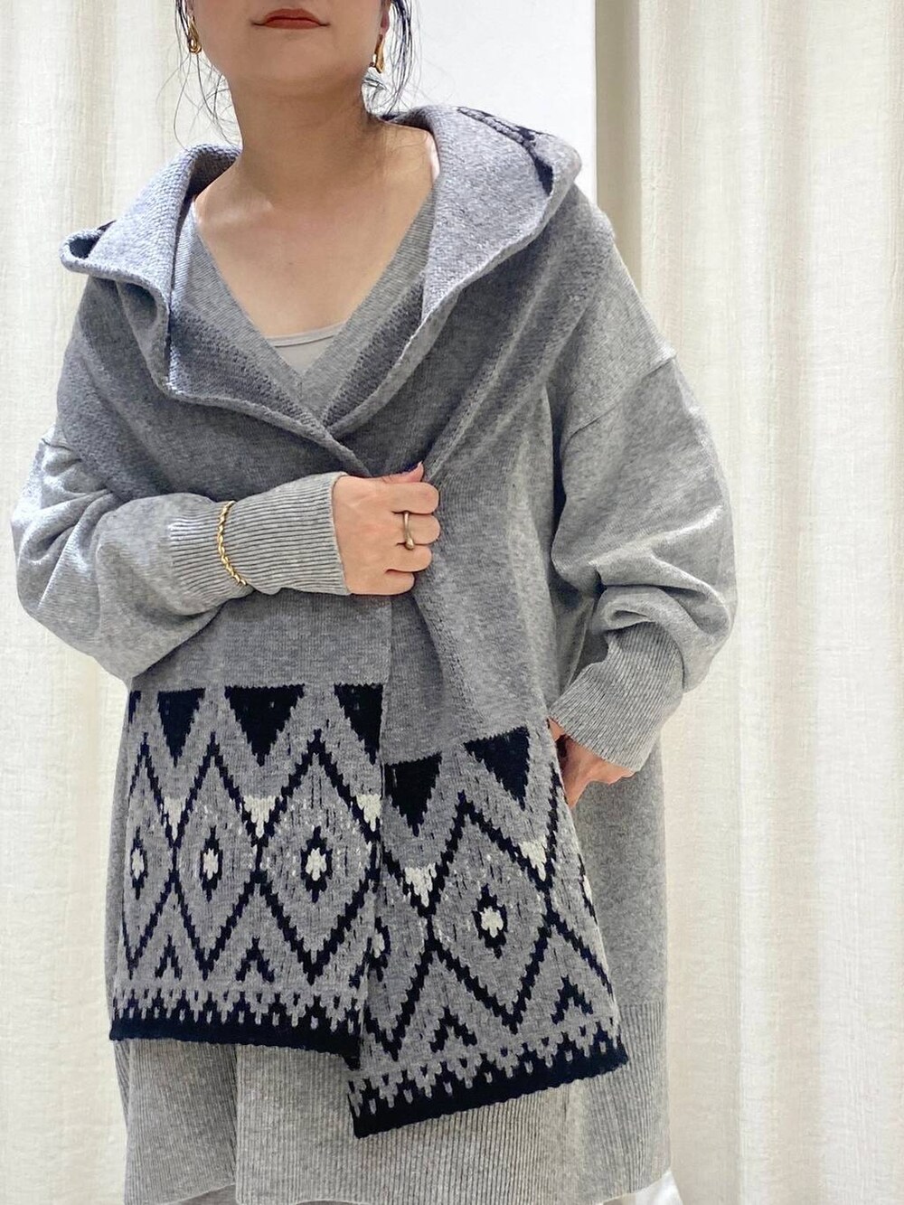 グレー系のニット/セーター、ブラウン系のトレンチコート、グレー系のスウェットパンツを着用したレディースの秋コーディネートの5枚目の写真