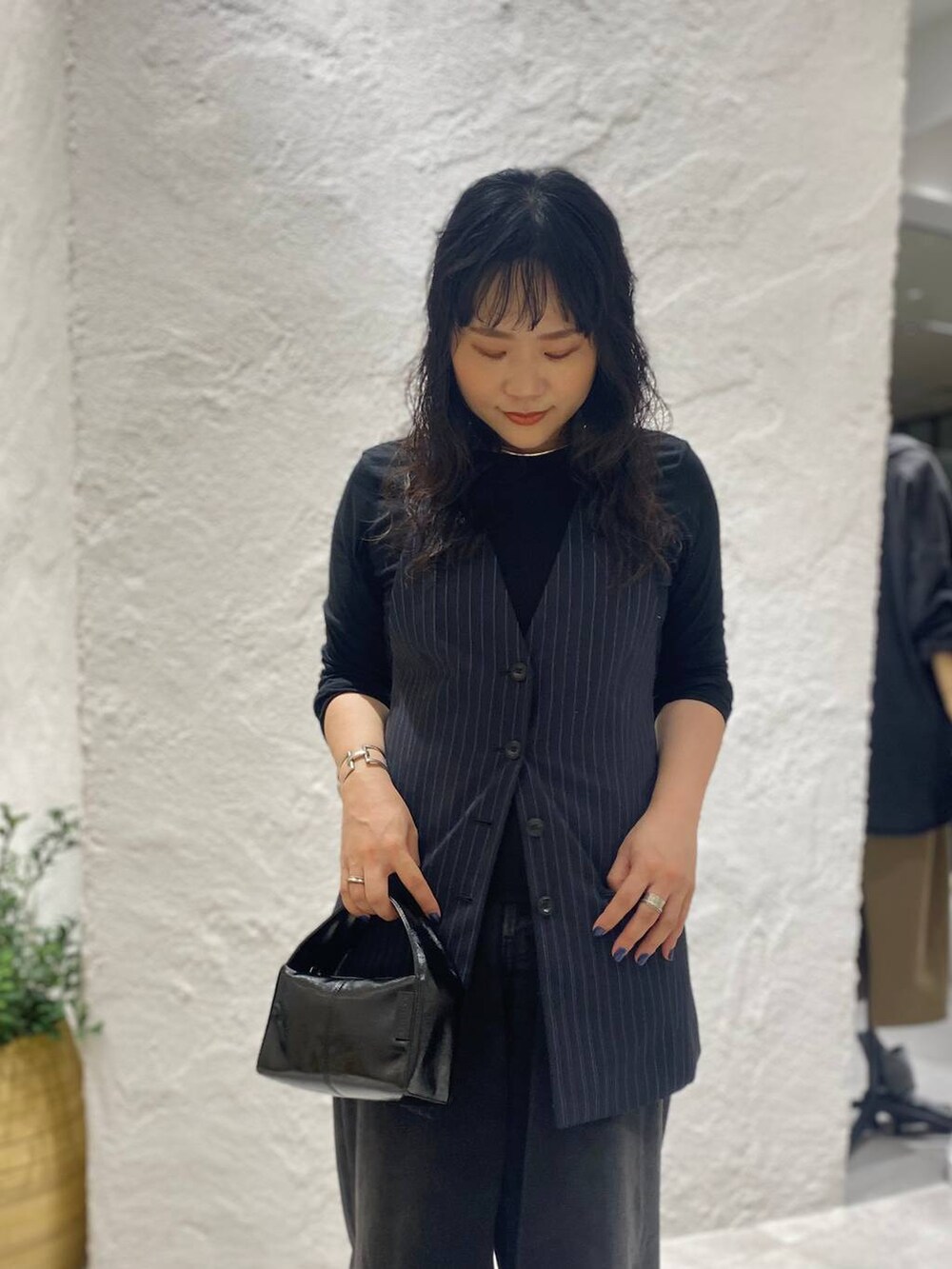 ブラック系のデニムパンツ、ブルー系のベスト、ブラック系のTシャツ/カットソーを着用したレディースの夏コーディネートの5枚目の写真