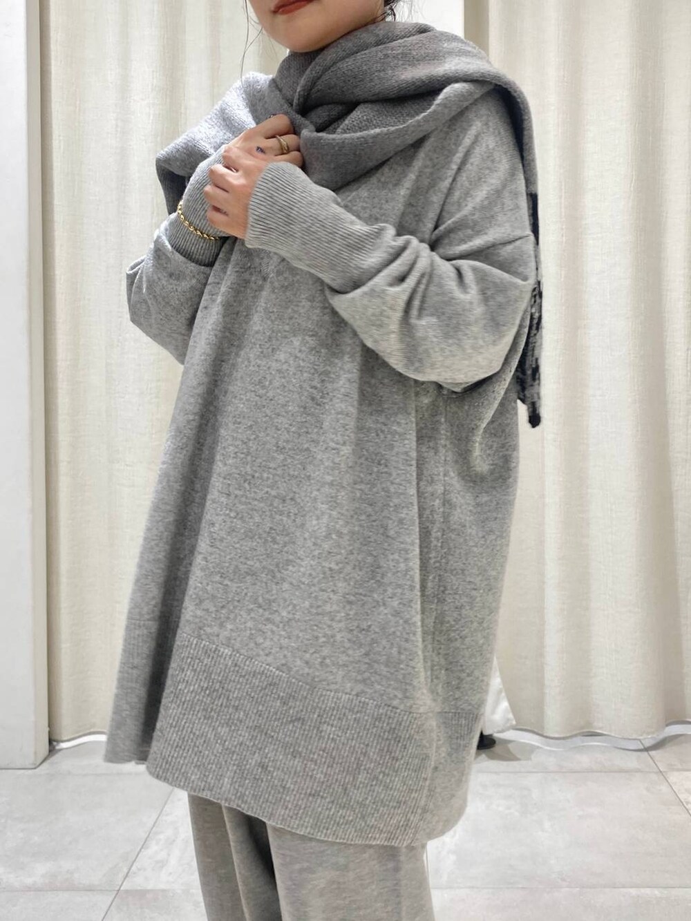 グレー系のニット/セーター、ブラウン系のトレンチコート、グレー系のスウェットパンツを着用したレディースの秋コーディネートの6枚目の写真