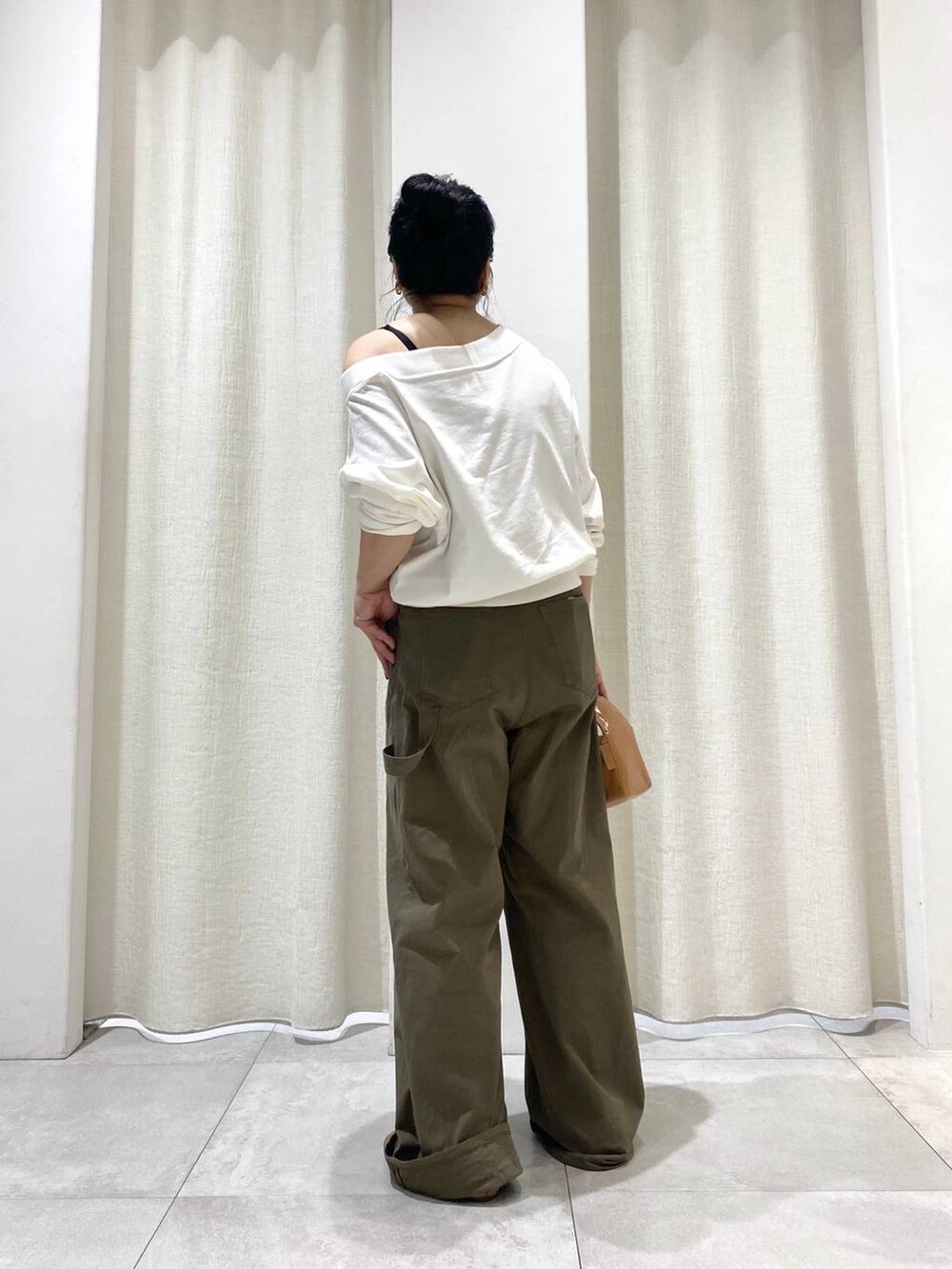 グリーン系のチノパンツ、ホワイト系のTシャツ/カットソーを着用したレディースの夏コーディネートの3枚目の写真