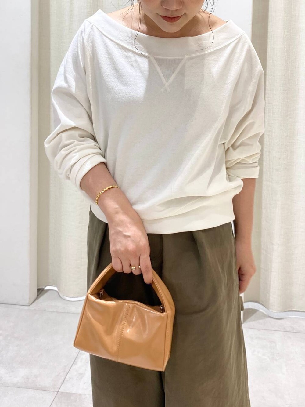 グリーン系のチノパンツ、ホワイト系のTシャツ/カットソーを着用したレディースの夏コーディネートの5枚目の写真