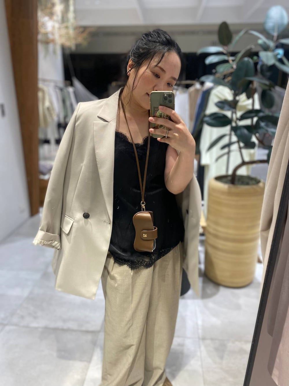 ブラック系のキャミソール、ベージュ系のボストンバッグ、ベージュ系のテーラードジャケットを着用したレディースの春コーディネートの4枚目の写真