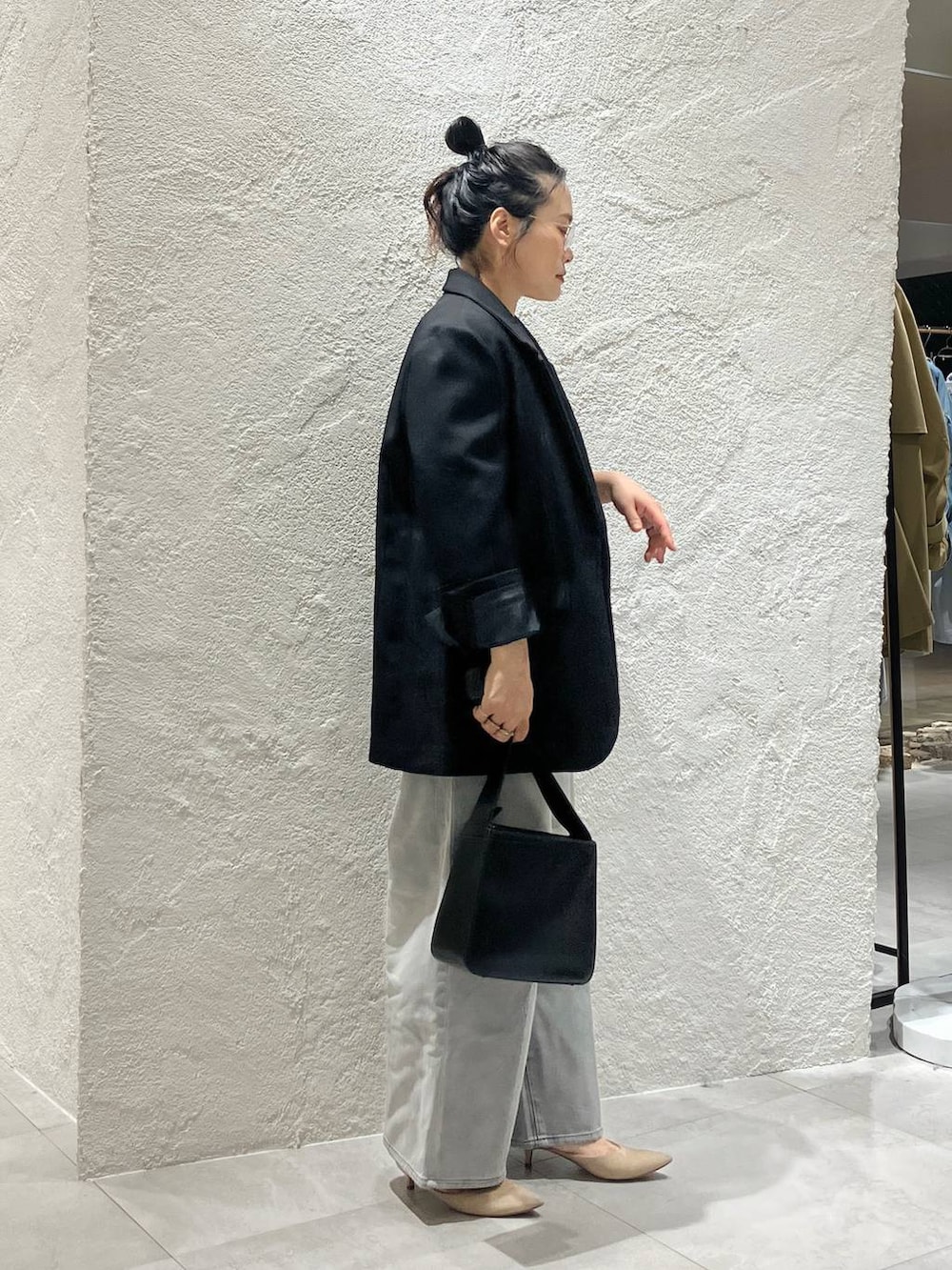 グレー系のデニムパンツ、ホワイト系のベスト、ブラック系のテーラードジャケットを着用したレディースの冬コーディネートの4枚目の写真