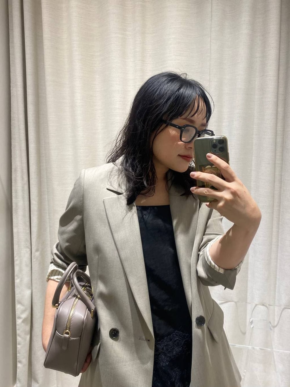 ブラック系のキャミソール、ベージュ系のボストンバッグ、ベージュ系のテーラードジャケットを着用したレディースの春コーディネートの6枚目の写真