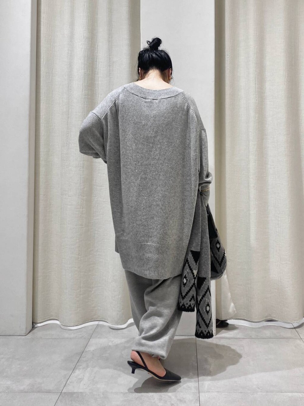 グレー系のニット/セーター、ブラウン系のトレンチコート、グレー系のスウェットパンツを着用したレディースの秋コーディネートの8枚目の写真