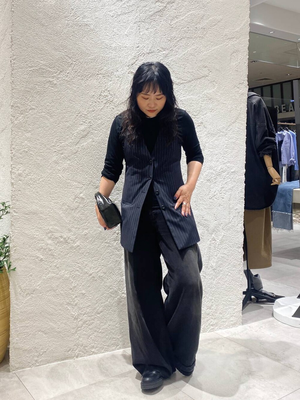 ブラック系のデニムパンツ、ブルー系のベスト、ブラック系のTシャツ/カットソーを着用したレディースの夏コーディネートの7枚目の写真