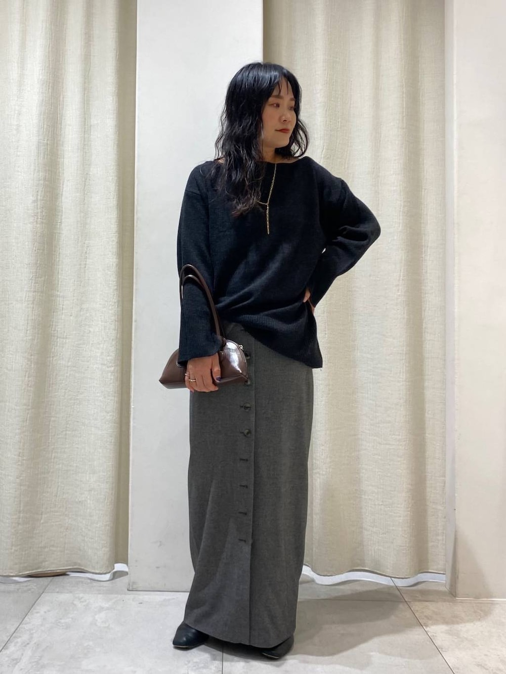 ブラック系のキャミソール、ブラウン系のショルダーバッグ、グレー系のニット/セーターを着用したレディースの秋コーディネートの6枚目の写真