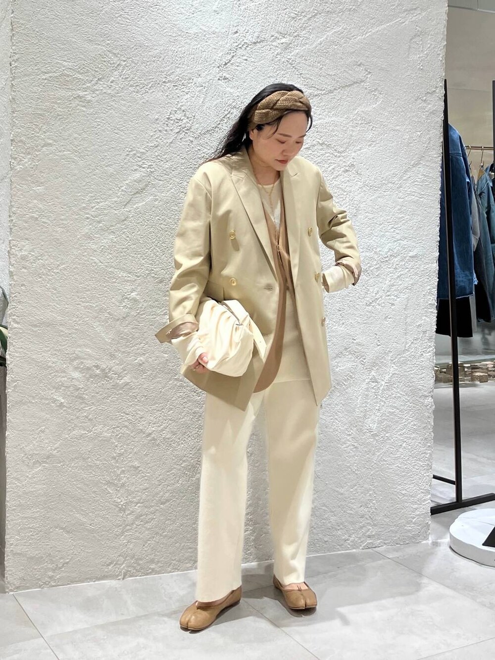 ベージュ系のショルダーバッグ、ベージュ系のテーラードジャケット、ベージュ系のその他アウターを着用したレディースの冬コーディネートの4枚目の写真