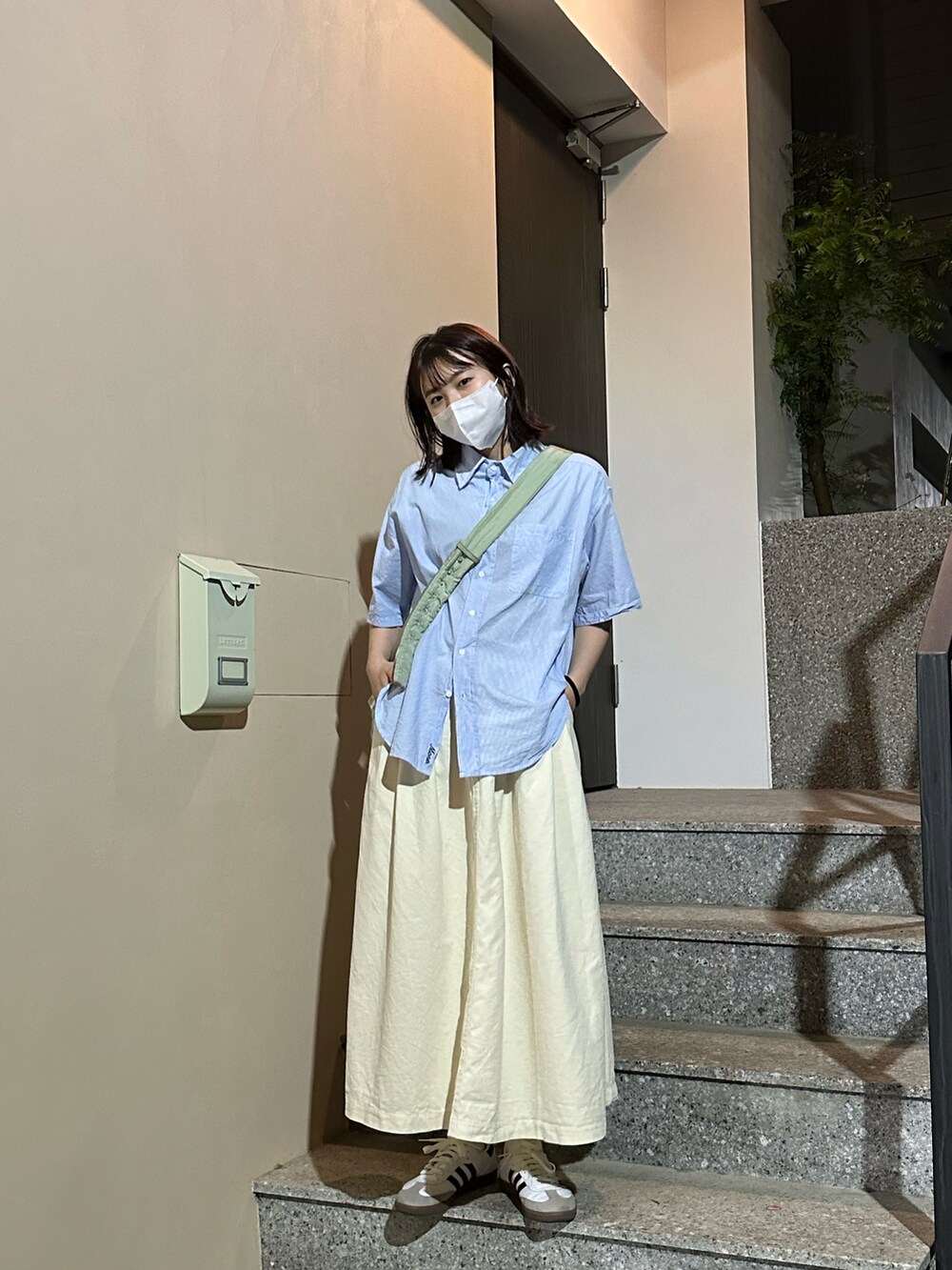 ホワイト系のスニーカーを着用したレディースの春コーディネートの3枚目の写真