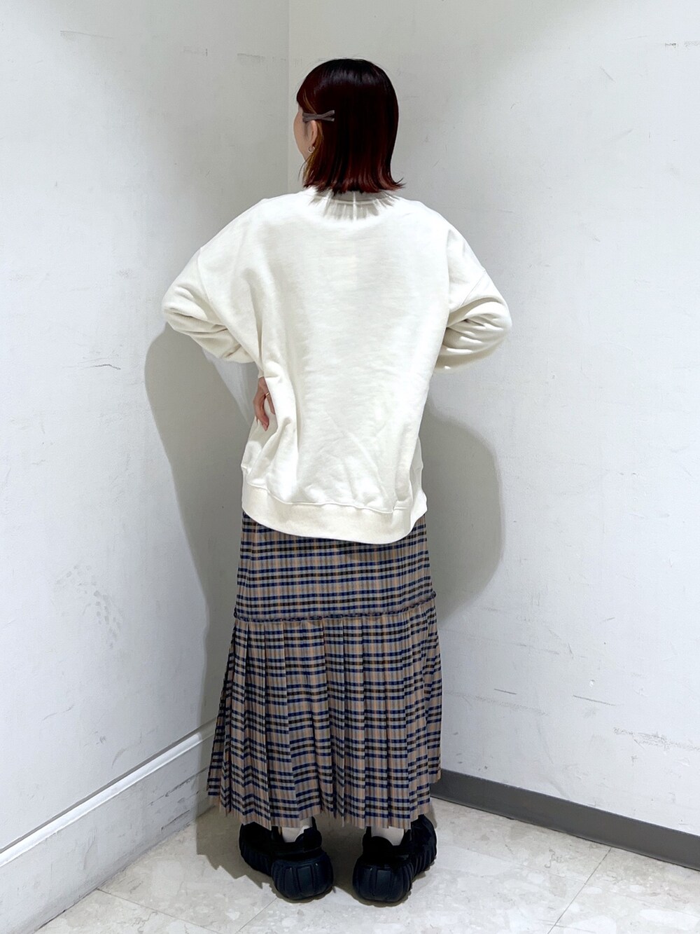 ホワイト系のスウェット、グレー系のスカート、パープル系のショルダーバッグを着用したレディースの冬コーディネートの2枚目の写真