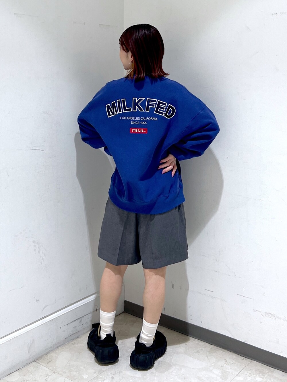 ブルー系のスウェット、グレー系のその他パンツ、ブラック系のショルダーバッグを着用したレディースの冬コーディネートの2枚目の写真