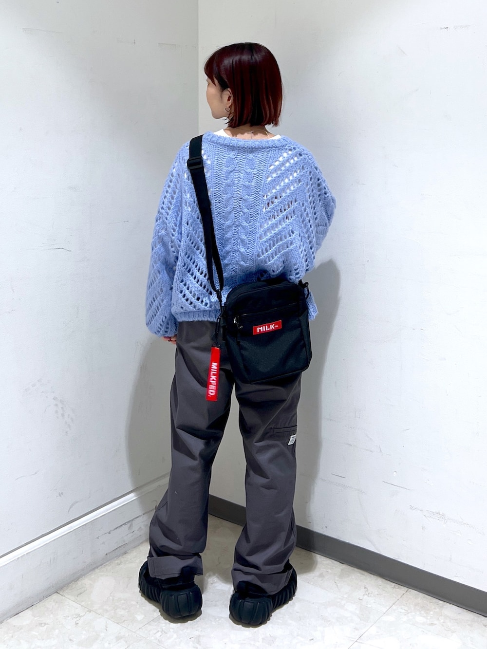 ブルー系のニット/セーター、グレー系のその他パンツを着用したレディースの秋コーディネートの2枚目の写真